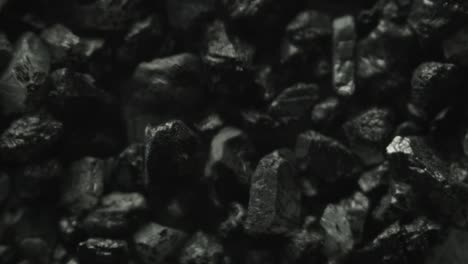 extreme macro of black stones moving through vibrations of sound