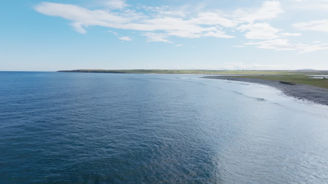 Aerial view over Barvas Beach on the Isle of Lewis, showing smooth Atlantic swell lines reaching the shoreline under soft Hebridean light. Quiet, remote coastal landscape of the Outer Hebrides