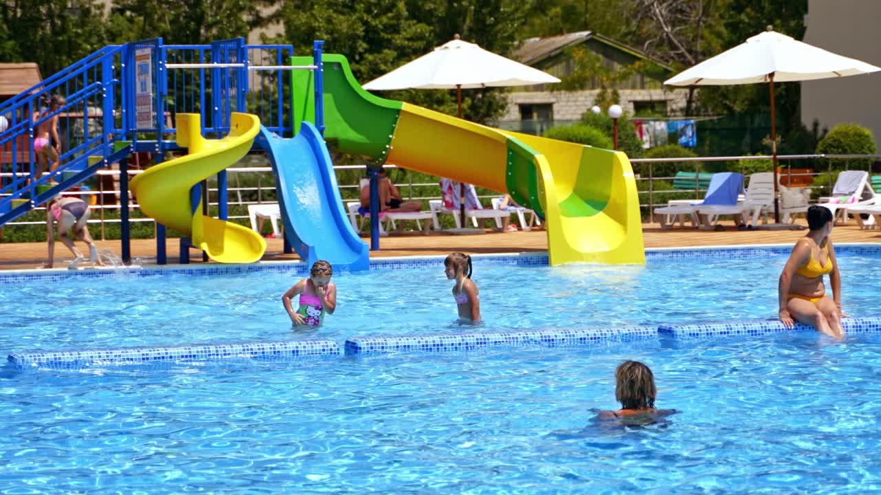 People in swimming pool. People having fun at open air swimming pool