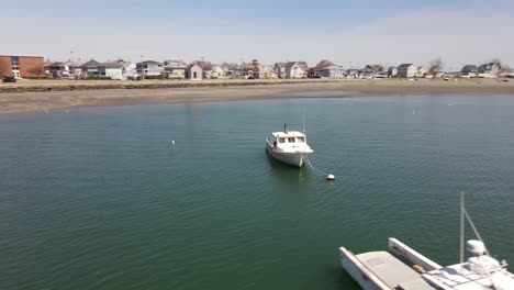 drone circle of a weathered lobster boat moored near the shore