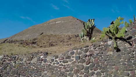 Stunning-beauty-of-a-Teotihuacan's-Pyramid,-with-the-magnificent-blue-sky-above,-the-Pyramid-stands-tall-amidst-lush-green-surroundings