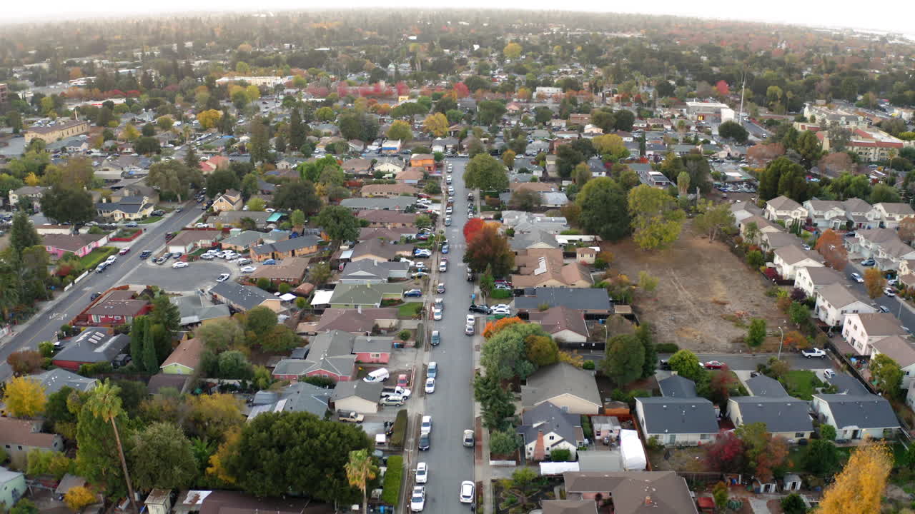 Aerial view of a suburban neighborhood with houses and autumn trees