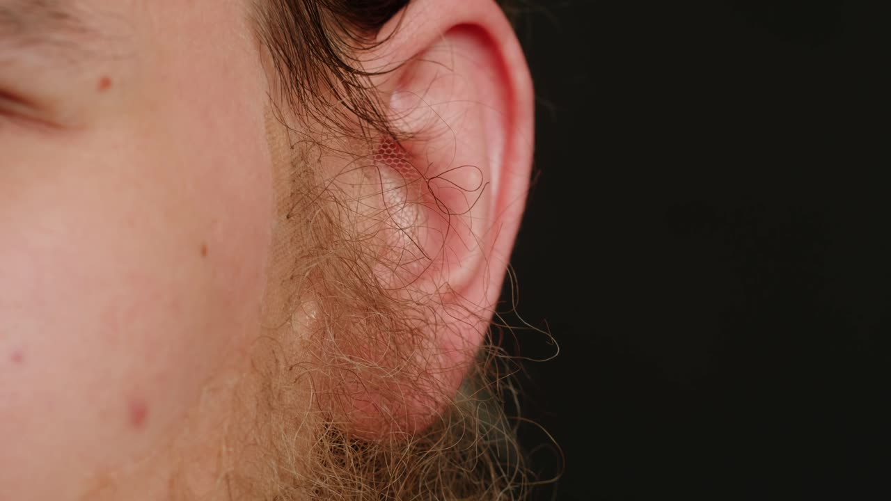 Make up artist making Disheveled blond beard for a man in theater, actors sfx cinema make up, close-up. Mens fashion, halloween style. making old guy.