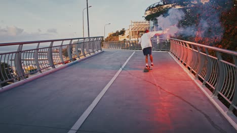 millennial guy skateboarding with red signal fire on bridge, slow motion