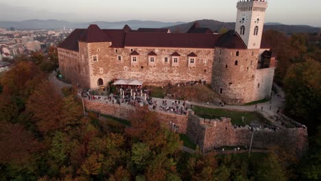 zoom out shot of historic ljubljana castle in slovenia with tourists at dusk time