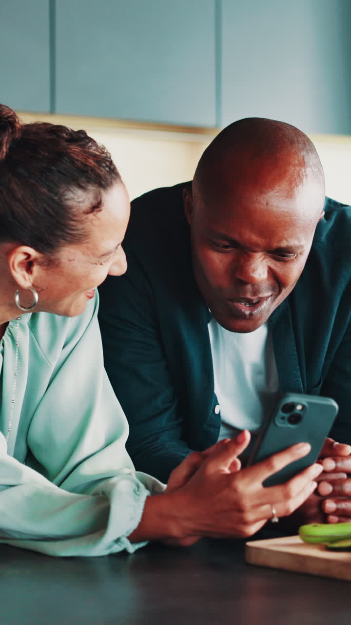 Happy Couple Laughing While Looking at Smartphone Together