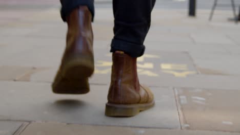 Tracking-Shot-of-Feet-Walking-Over-One-Way-Floor-Marking-In-Oxford-