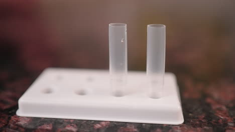 solution drops are squeezed into a tube for a covid-19 rapid test, slow motion