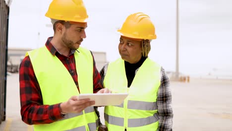 operadores industriales multirraciales que trabajan en la terminal logística de carga de contenedores