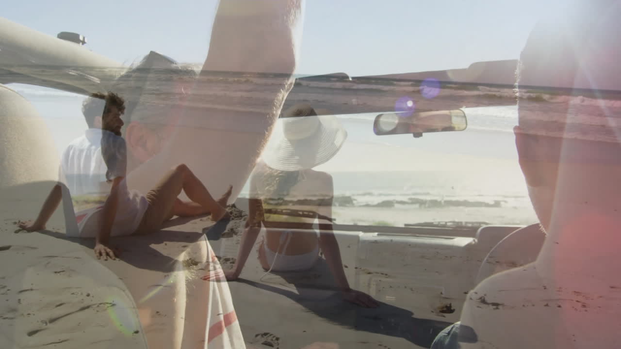 Relaxing on beach, couple with convertible car enjoying sunny day