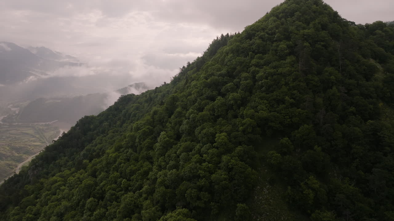 bosque nativo salvaje en la cima de una colina, con vistas a un pequeño pueblo georgiano, tiseli