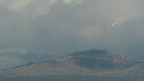 Aviones-Ganando-Altura-Y-Volando-Sobre-Montañas-En-El-Cielo-Nublado