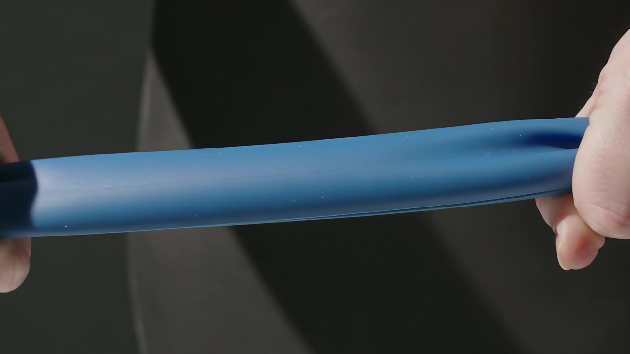Gripping and moving hands pulling blue elastic resistance band in studio, showing band elasticity