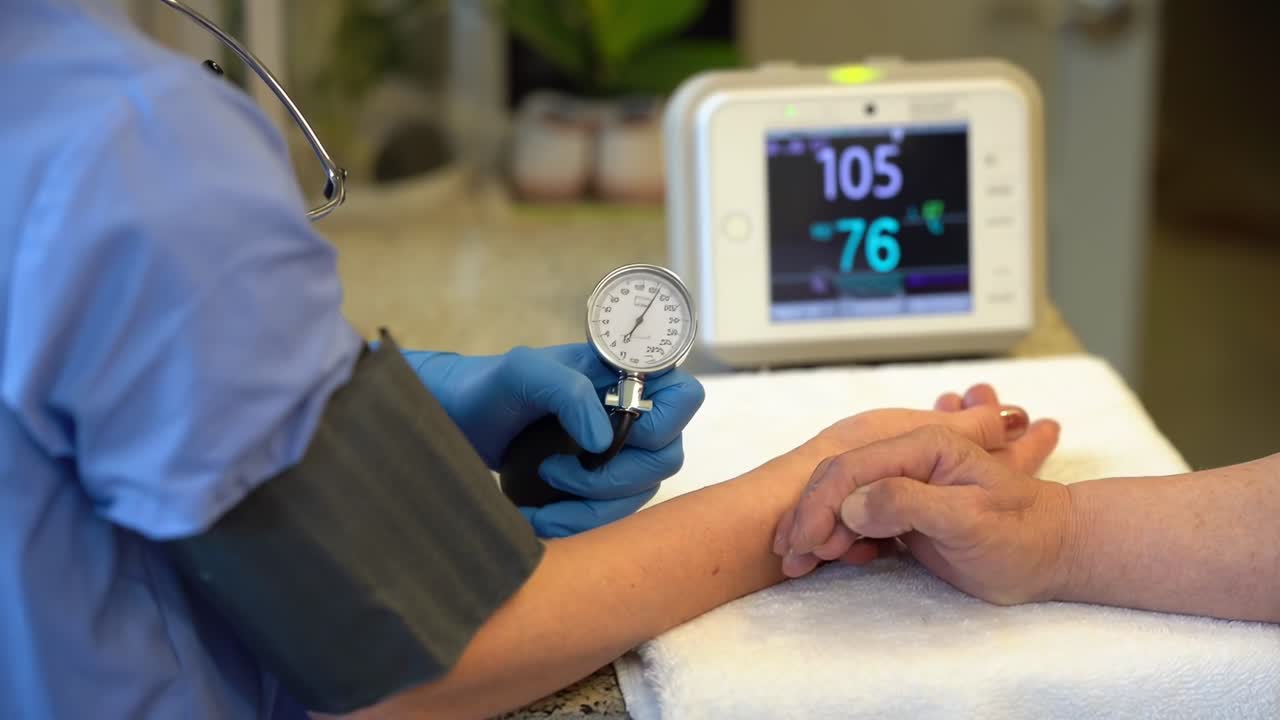 Video in primo piano di un'infermiera che misura la pressione sanguigna, che mostra l'assistenza medica.