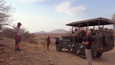 a tourist launches a drone with native guide and travel guide on safari in africa