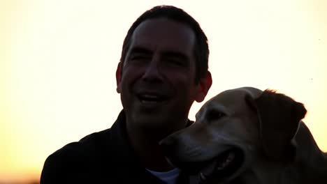 a man enjoys sunset moments with his loyal dog, capturing the essence of their bond in a serene outdoor setting