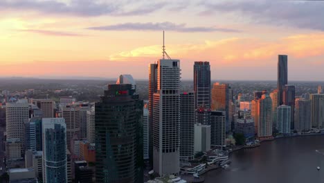 sunset scenery by the eagle street pier with brisbane city skyline in queensland, australia - aerial drone