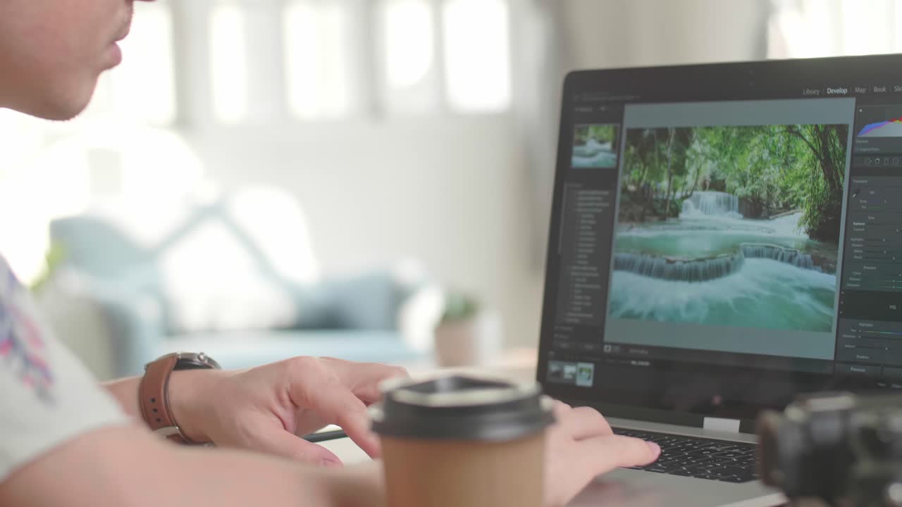 Person Editing a Photo of Waterfalls on a Laptop