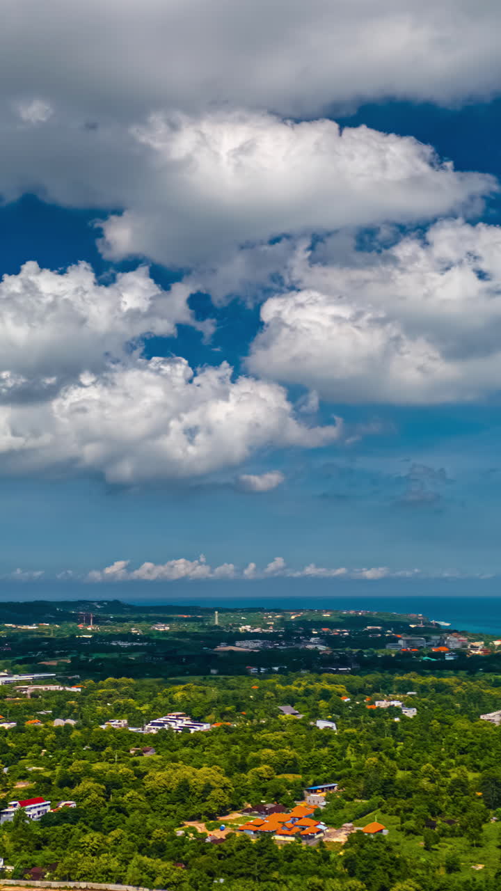 Drone timelapse of sunny Bali coast beneath scattered clouds and bright blue sky
