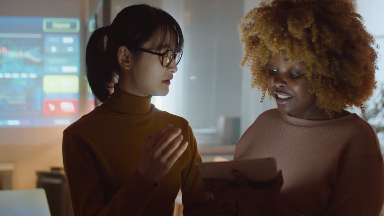 Diverse Female Colleagues Working with Tablet in Office at Night