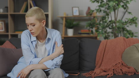 woman sitting on sofa, thoughtful expression