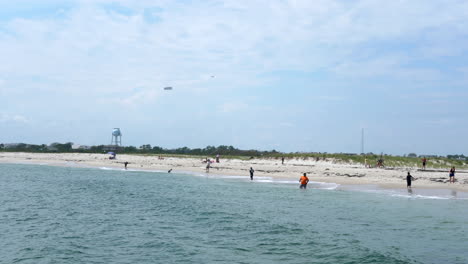 people enjoying the beach and fishing at the barnegat light in new jersey