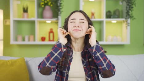 젊은 아시아 여성이 귀를  ⁇ 고 있습니다.