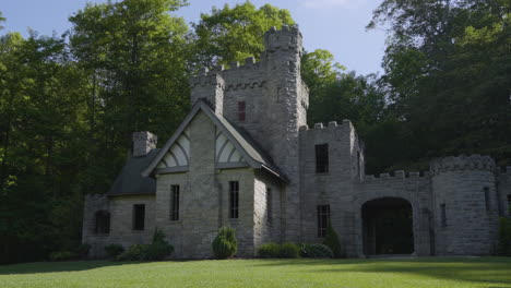 stately stone castle against a wooded backdrop with blue skies