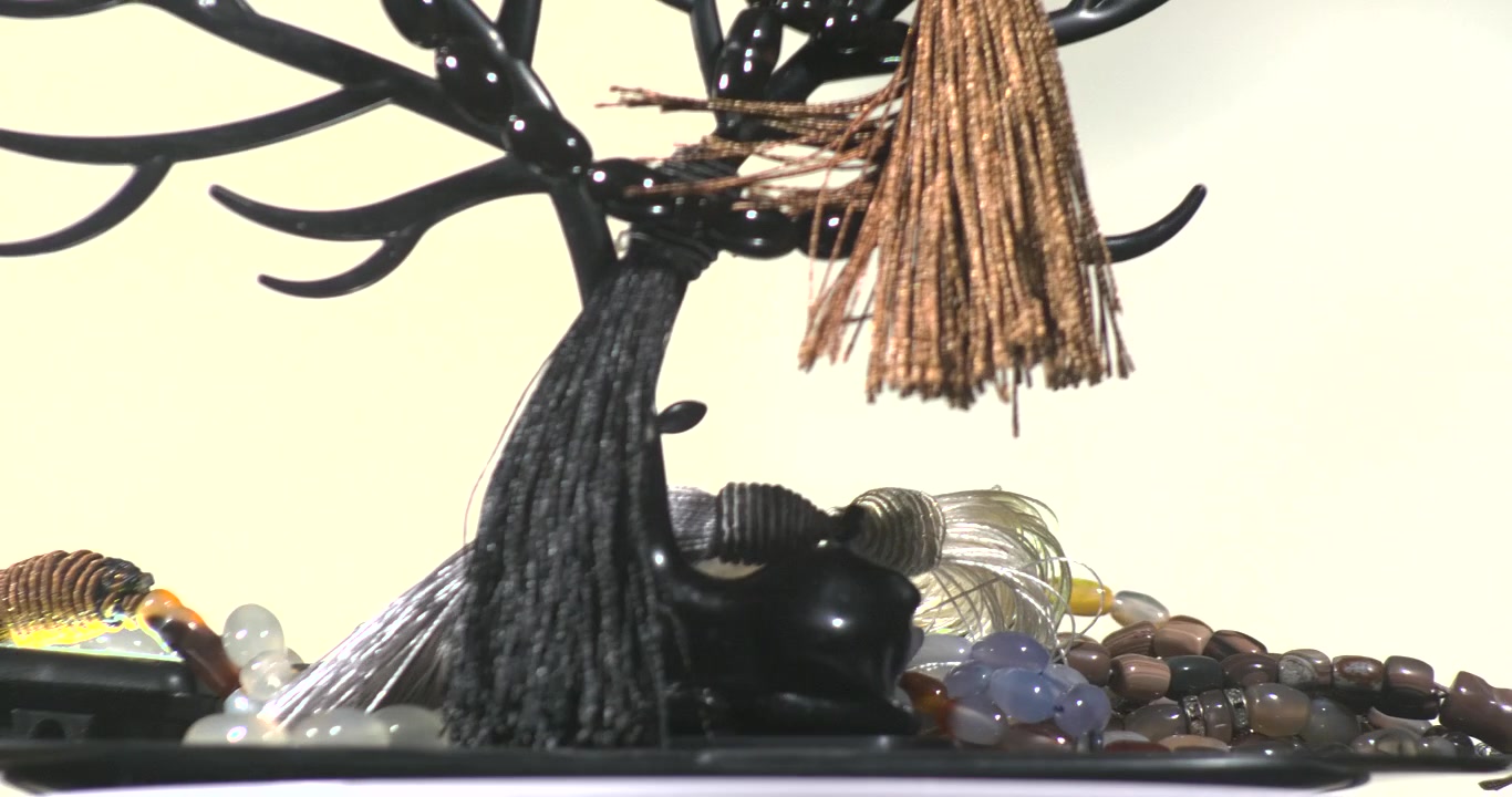 Rosário com pedras e gemas pretas, tecidos marrons em plataforma giratória para gráficos de Ramadã