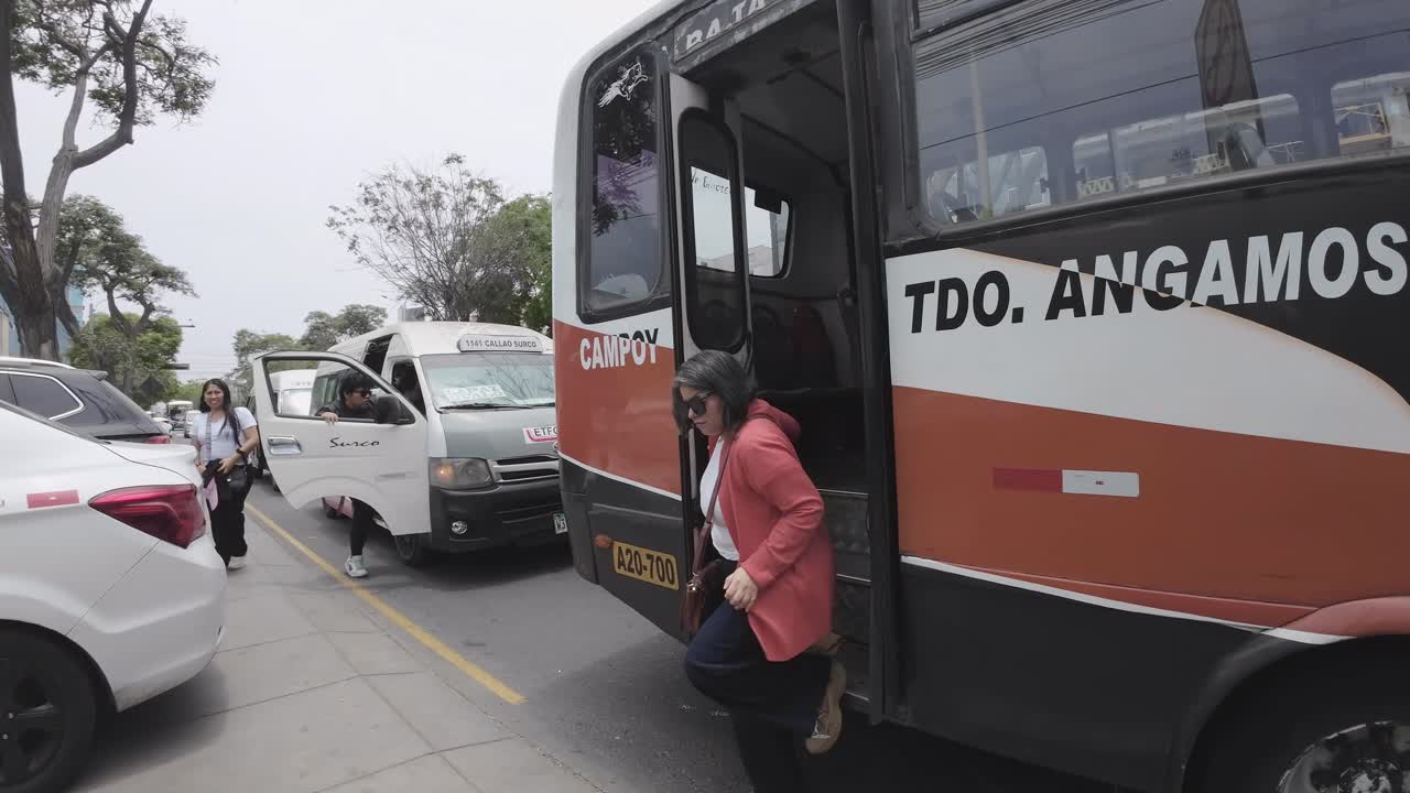 Pessoas desembarcando de um ônibus público em uma rua da cidade