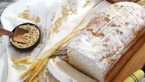 bread loaf with knife, wheat grains and oats