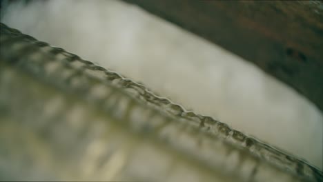 close up shot of the bubbles at the bottom of a waterfall in a canal way rushing