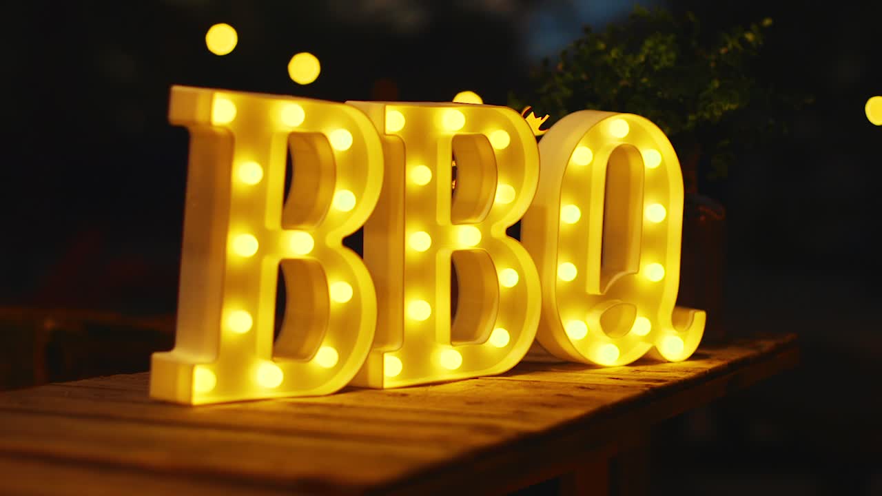 cartel de barbacoa amarillo brillante iluminado afuera por la noche en el caribe