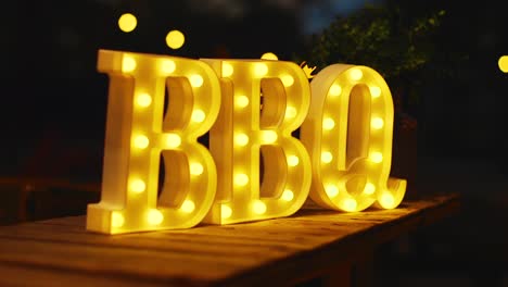 glowing yellow bbq sign lit up outside at night in the caribbean