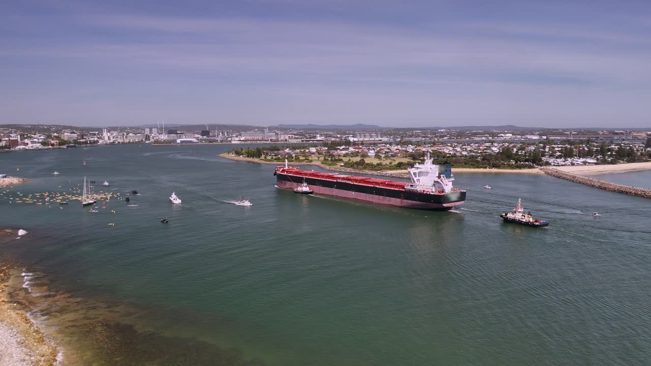 Oil tanker entering harbour is met by flotilla of boats protesting oil