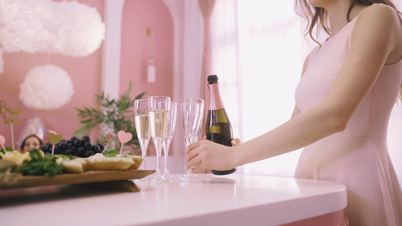 탁자 위의 크리스털 잔에 샴페인을 붓는 여성의 모습을 가까이에서
