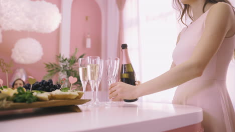 Vista-De-Cerca-De-Una-Mujer-Sirviendo-Champán-En-Copas-De-Cristal-Sobre-La-Mesa