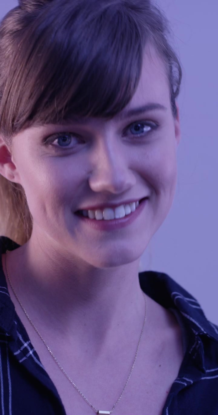 Giovane donna sorridente che guarda la fotocamera in studio