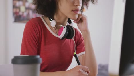 mujer de raza mixta trabajando en computadora en una oficina creativa