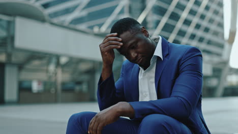 stressed businessman sitting alone in urban environment
