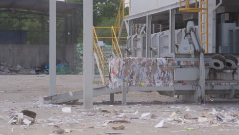 Wind-blows-dust-and-paper-trash-over-deserted-paper-recycling-facility,-static