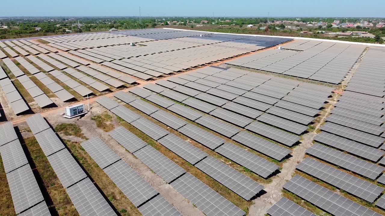 Flying over new solar panels at photovoltaic power plant under construction. Renewable electric energy
