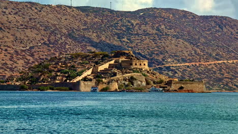 historical island fortress with boats docked in clear waters under a sunny sky