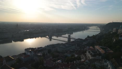 cinematic establishing drone shot above danube river in budapest at sunrise