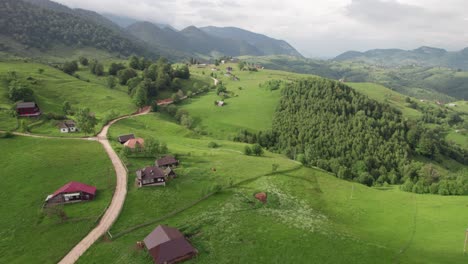 Un-Sereno-Pueblo-De-Montaña-Con-Caminos-Sinuosos-Y-Exuberante-Vegetación,-Filmado-A-La-Luz-Del-Día,-Vista-Aérea