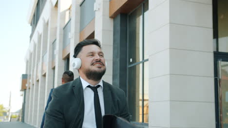 businessman walking and listening to music in the city