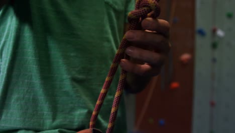 hombre atando la cuerda en el gimnasio de bouldering 4k