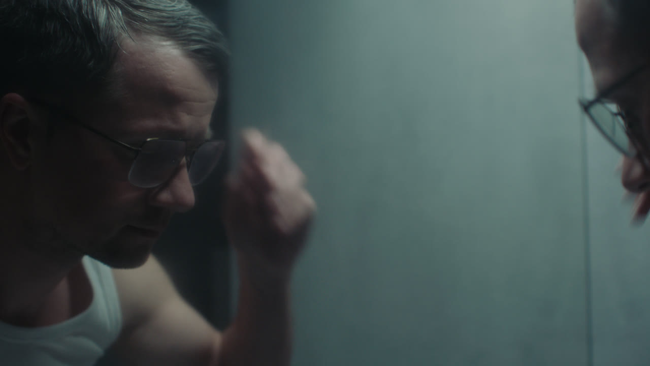 A sad man in the bathroom during his morning routine