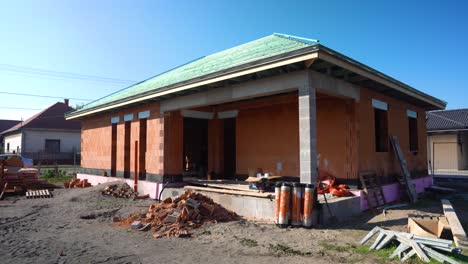 brick house under construction with green roof battens installed during strapping phase