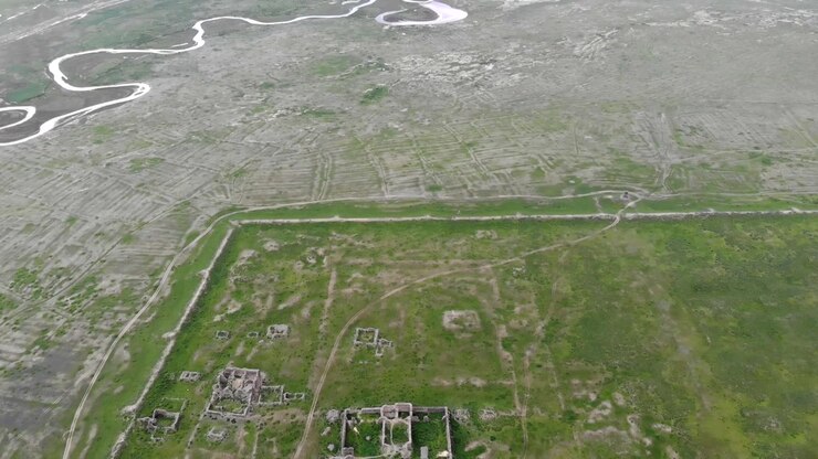 Aerial View of Ancient Ruins in a Vast Green Landscape